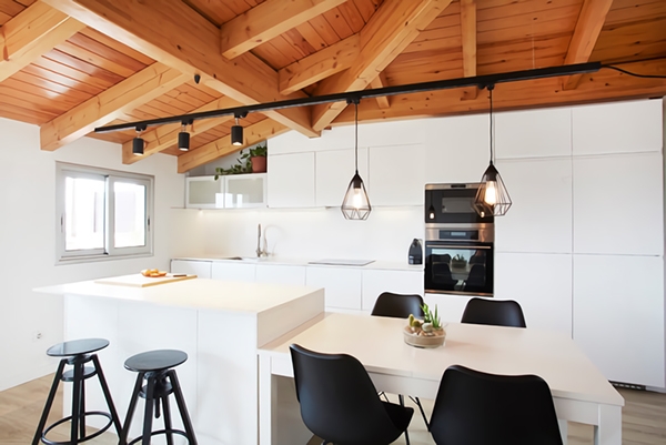 Una cocina blanca con isla, madera y acentos negros