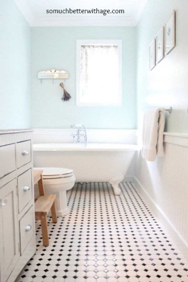 Un baño pintado de azul claro con friso de madera blanca