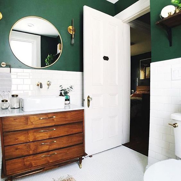 Un baño pintado de verde con azulejos blancos