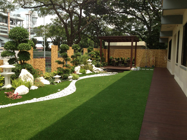 Un jardín grande y moderno con césped, flores y vegetación