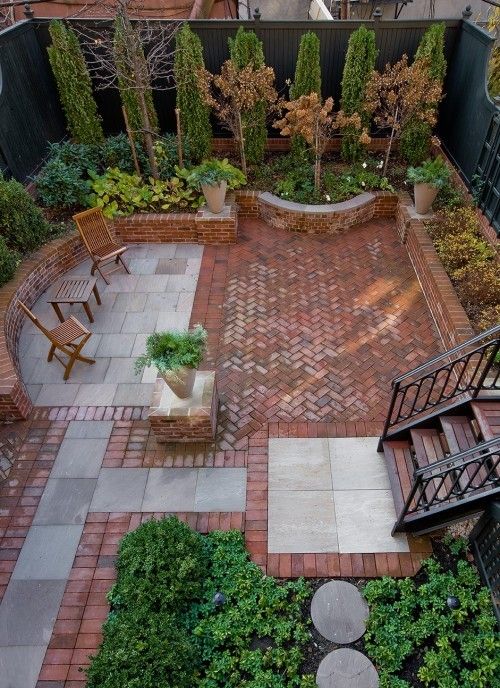 Un patio sin césped con mosaico de piedra y ladrillo de barro